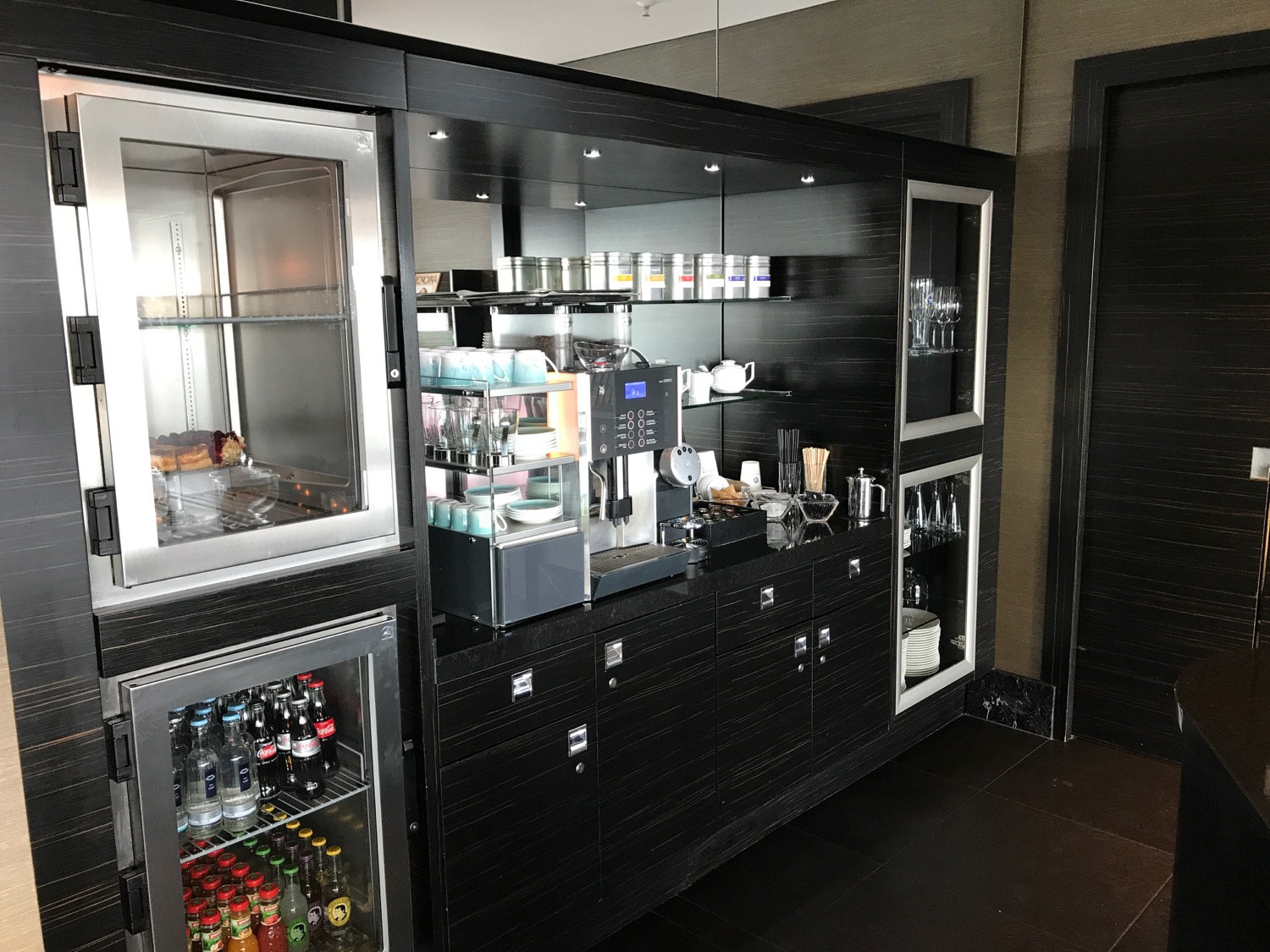 a black cabinet with a glass door and a coffee machine