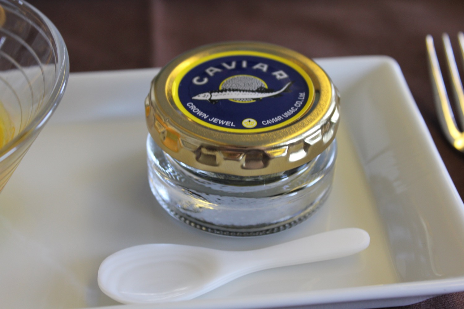 a small glass jar with a lid and a spoon on a plate