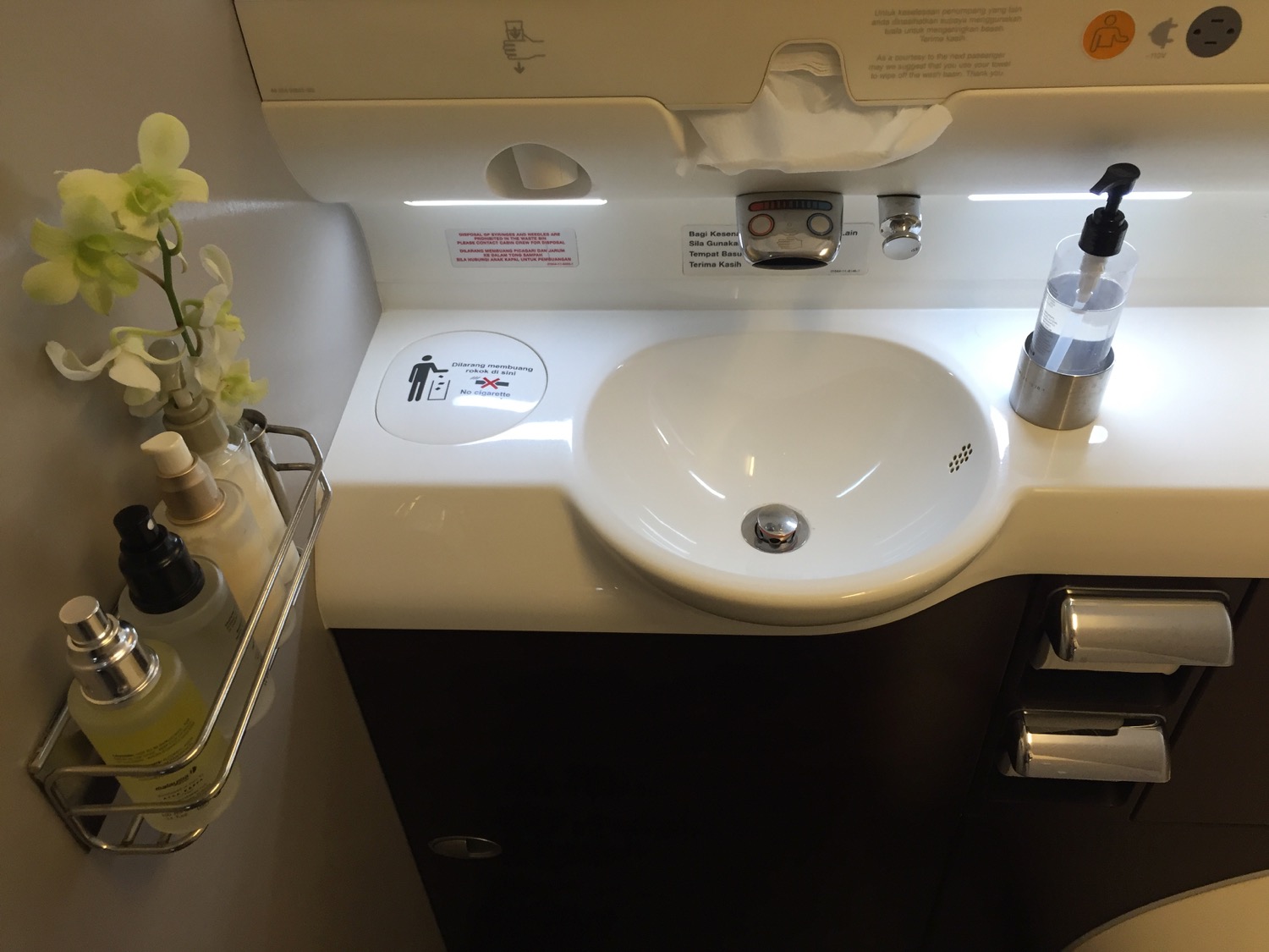 a sink with soap dispenser and a flower