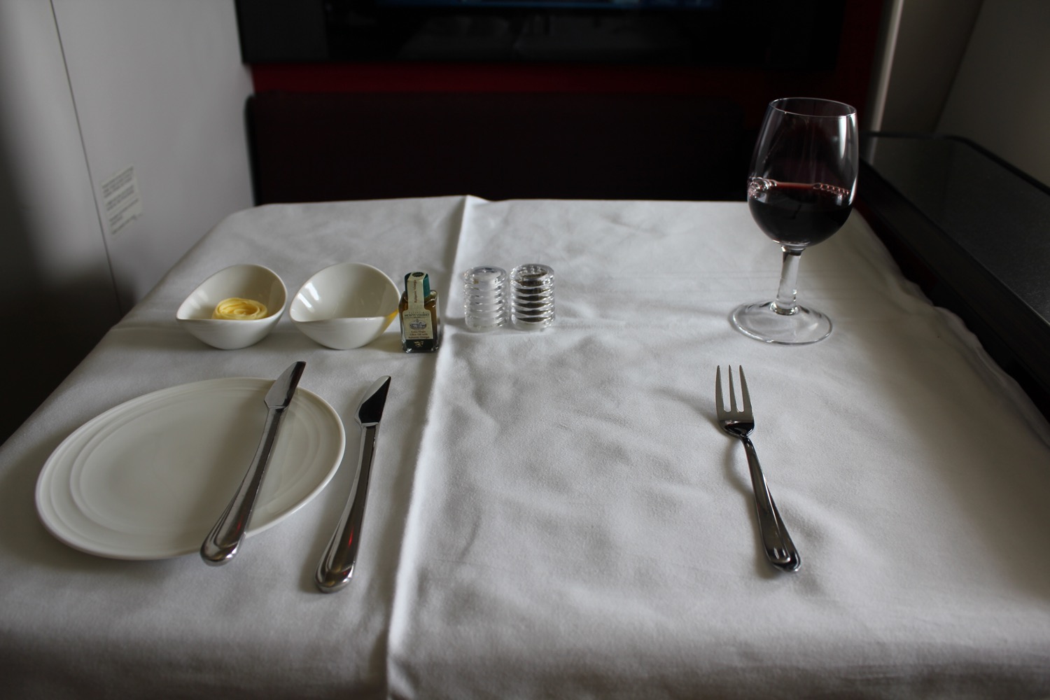 a table with a glass of wine and a plate with butter and a knife