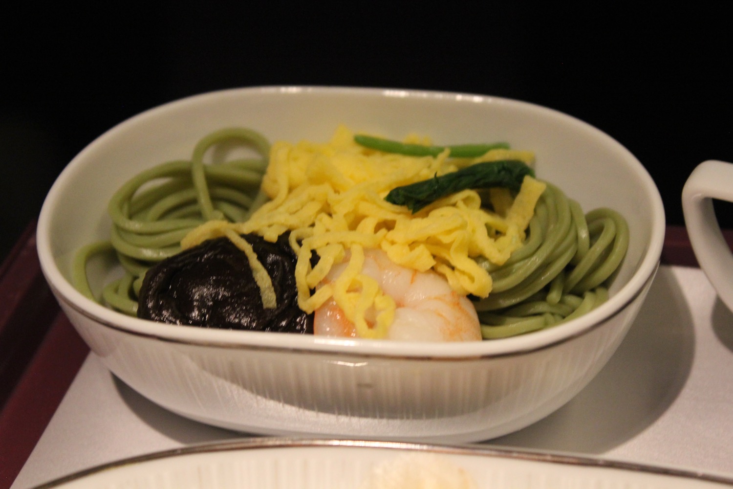 a bowl of noodles with shrimp and vegetables