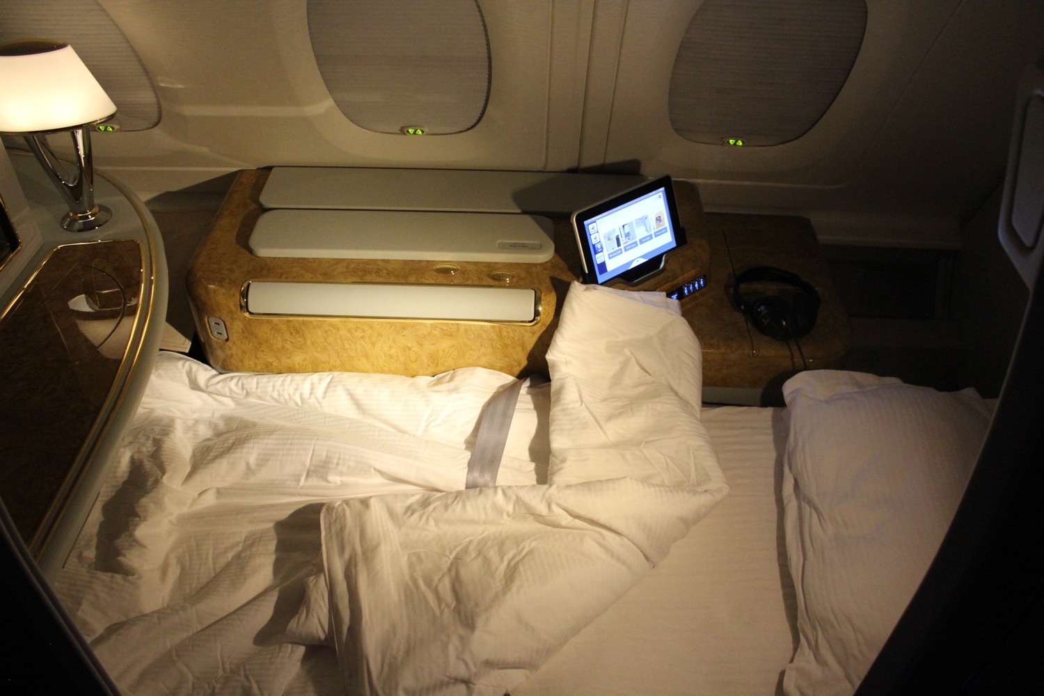 a bed with a laptop and a pillow on it