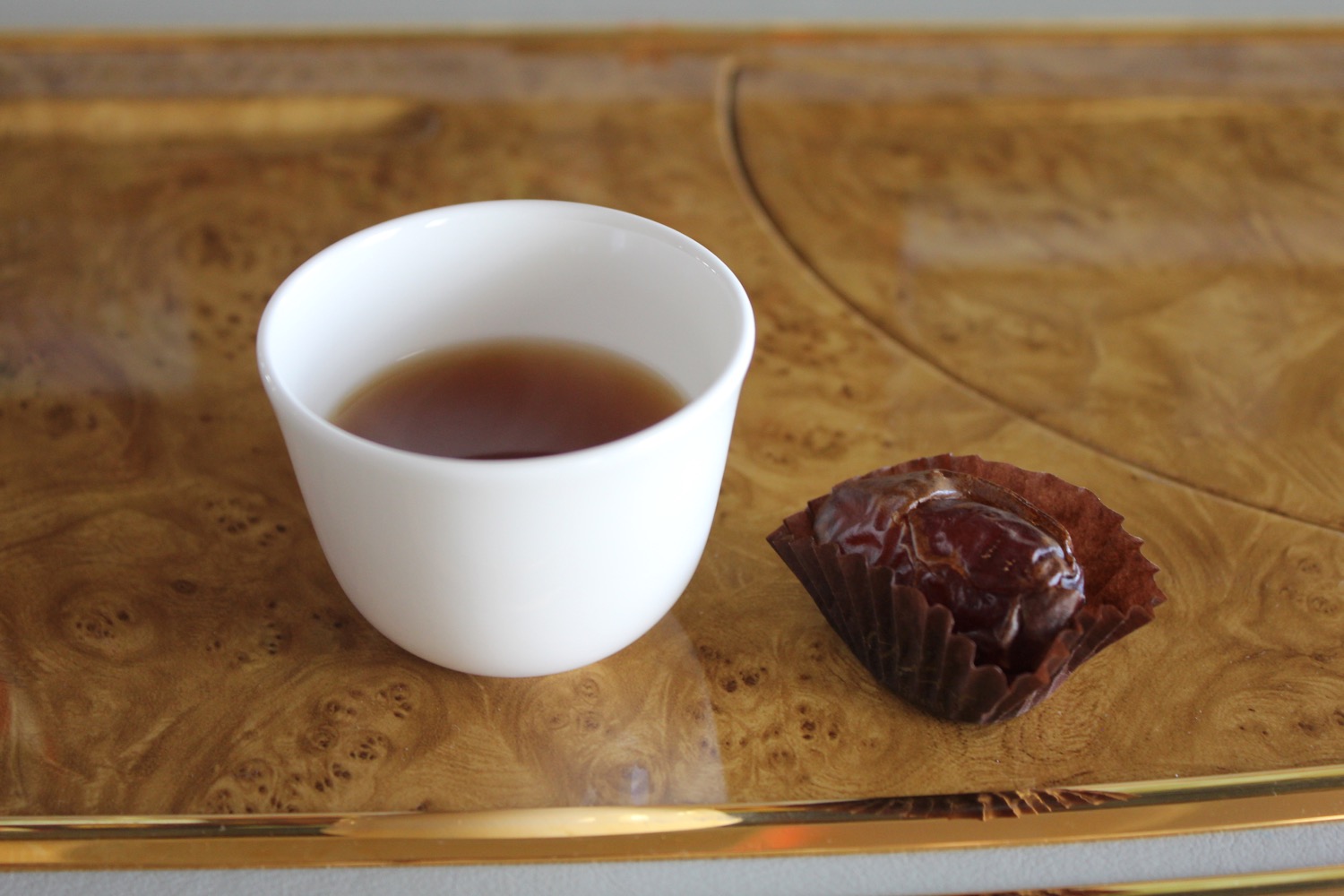 a cup of tea and a candy on a tray