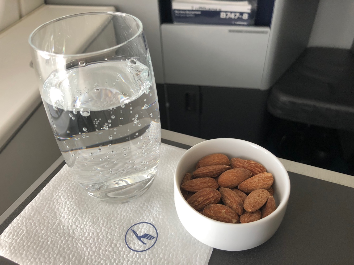 a bowl of almonds and a glass of water on a table