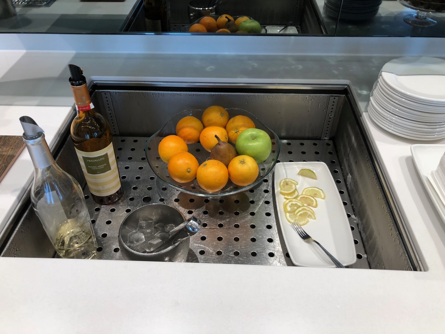 a bowl of fruit and a bottle of wine on a counter