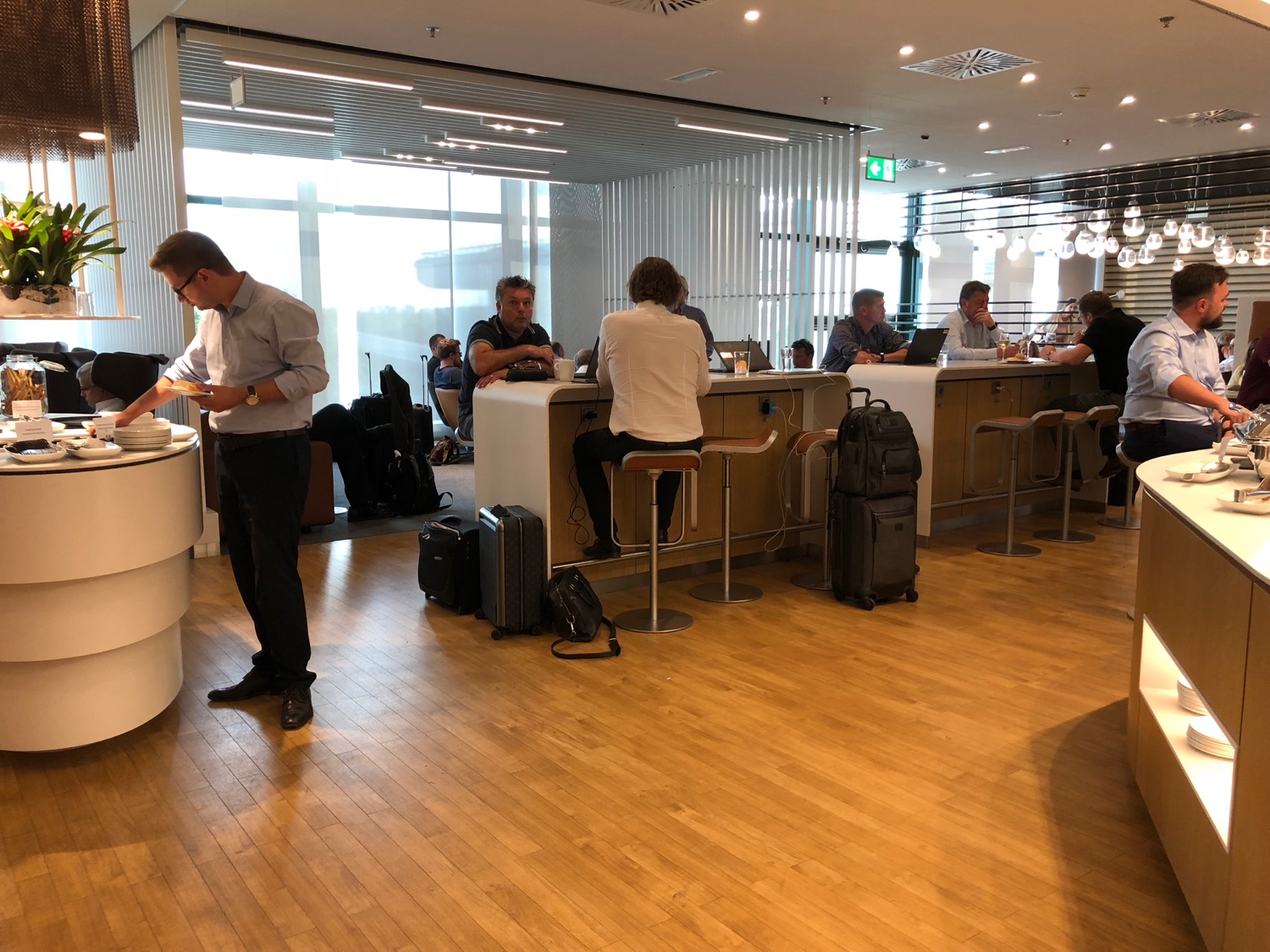 people sitting at a counter in a room with luggage