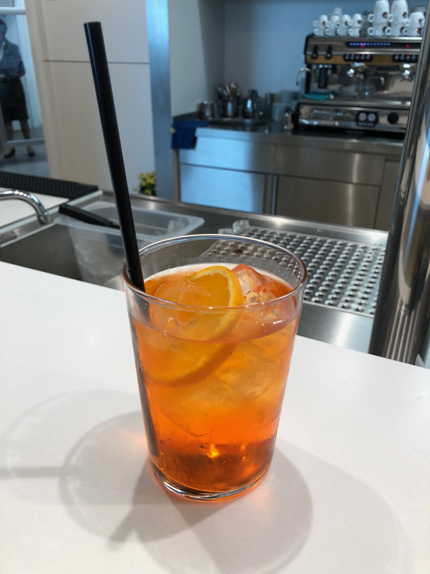 a glass of orange liquid with a straw
