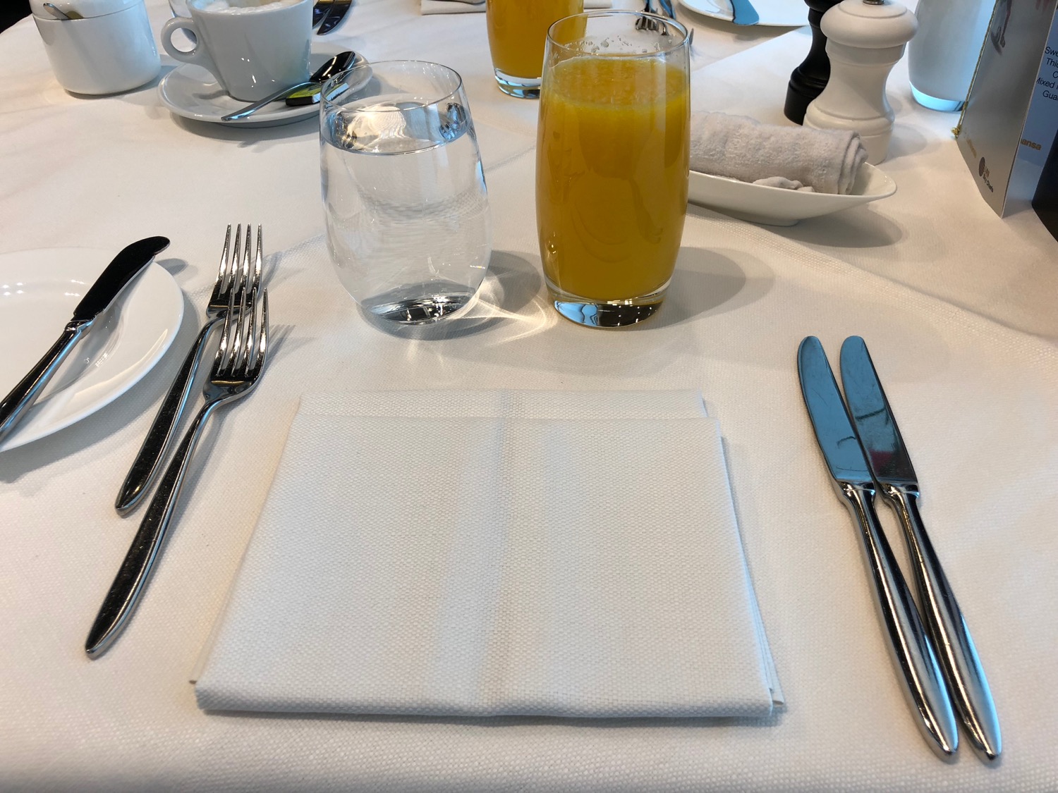 a table with a napkin and glasses of juice