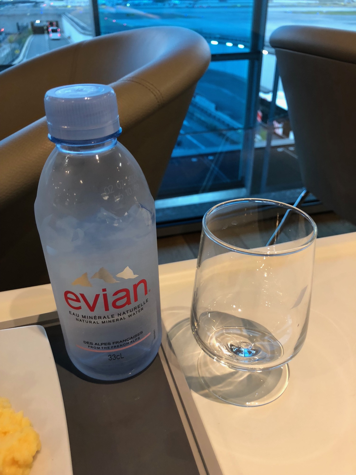 a bottle of water next to a glass