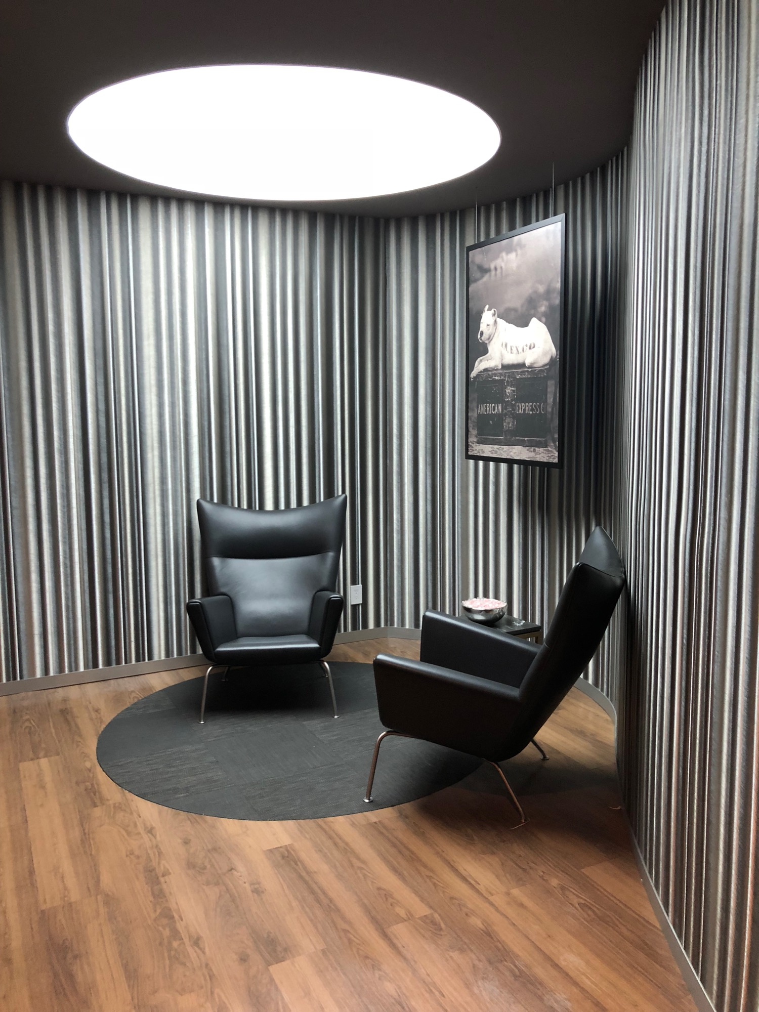 a room with black chairs and a picture on the wall