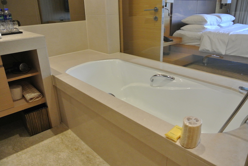 Soaking tub with glass through to bedroom/harbor view.