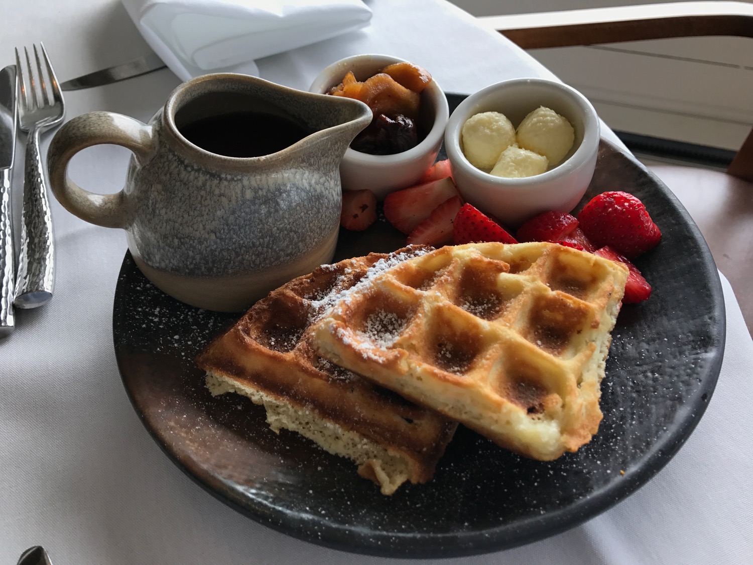 a plate of waffles and fruit