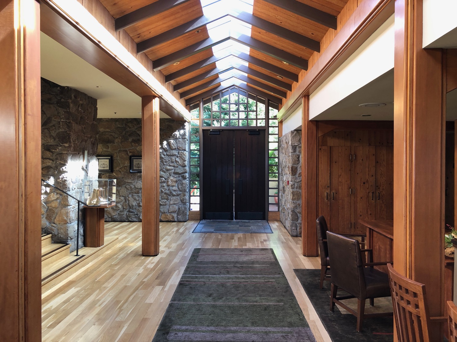 a hallway with a stone wall and a wood floor