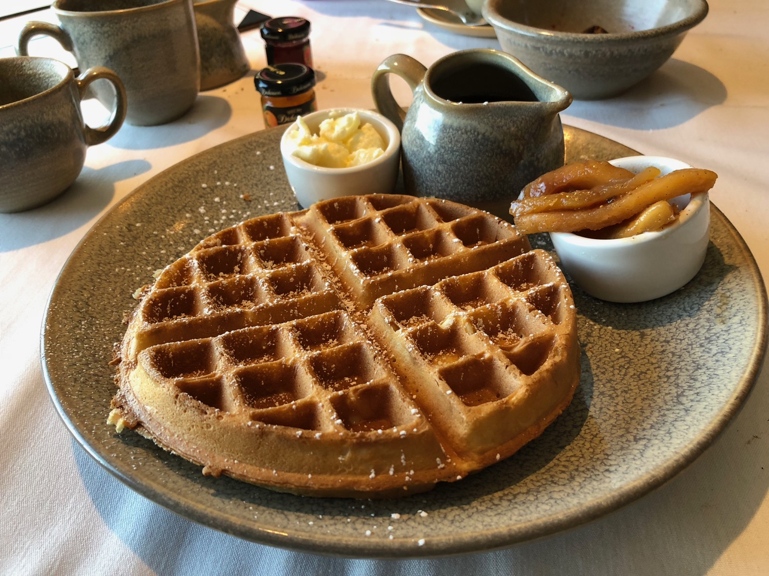 a waffle with syrup and french fries on a plate