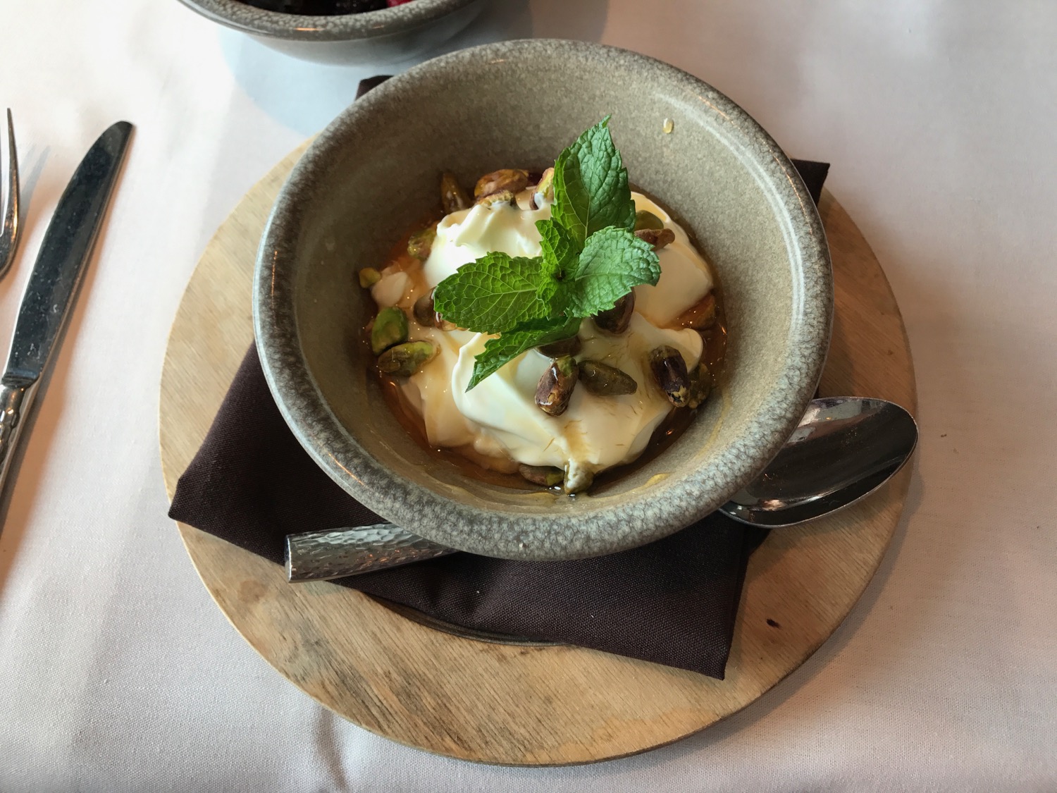 a bowl of food with a leaf of mint on top