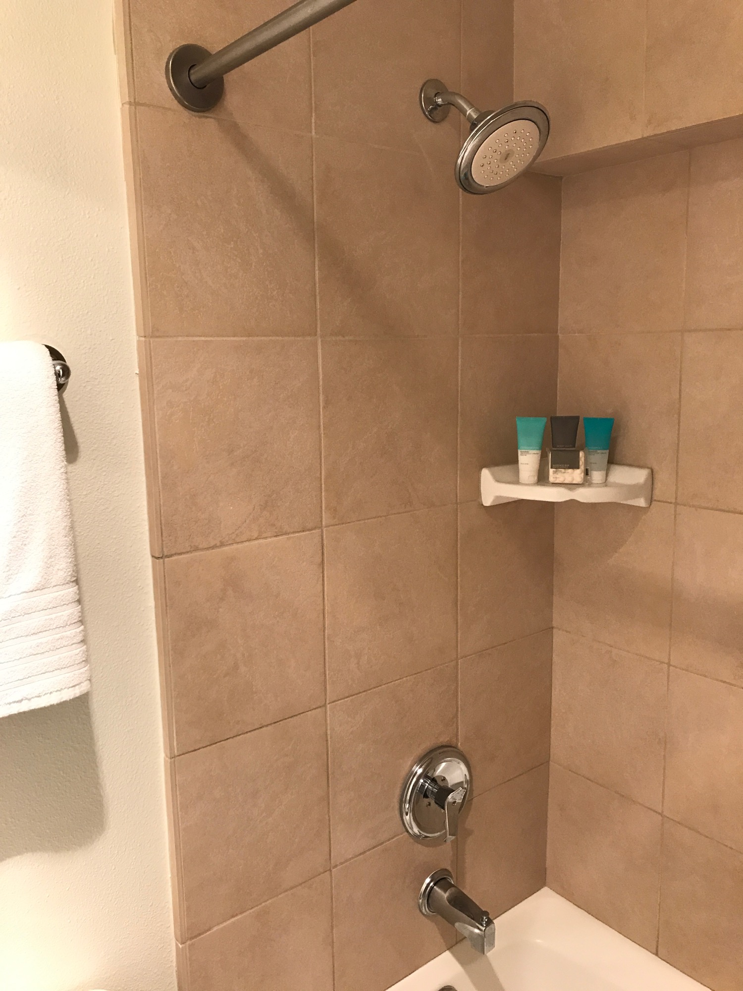 a shower with a shower head and a towel