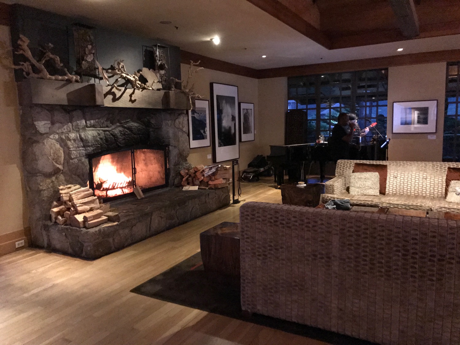 a room with a fireplace and a man playing a guitar