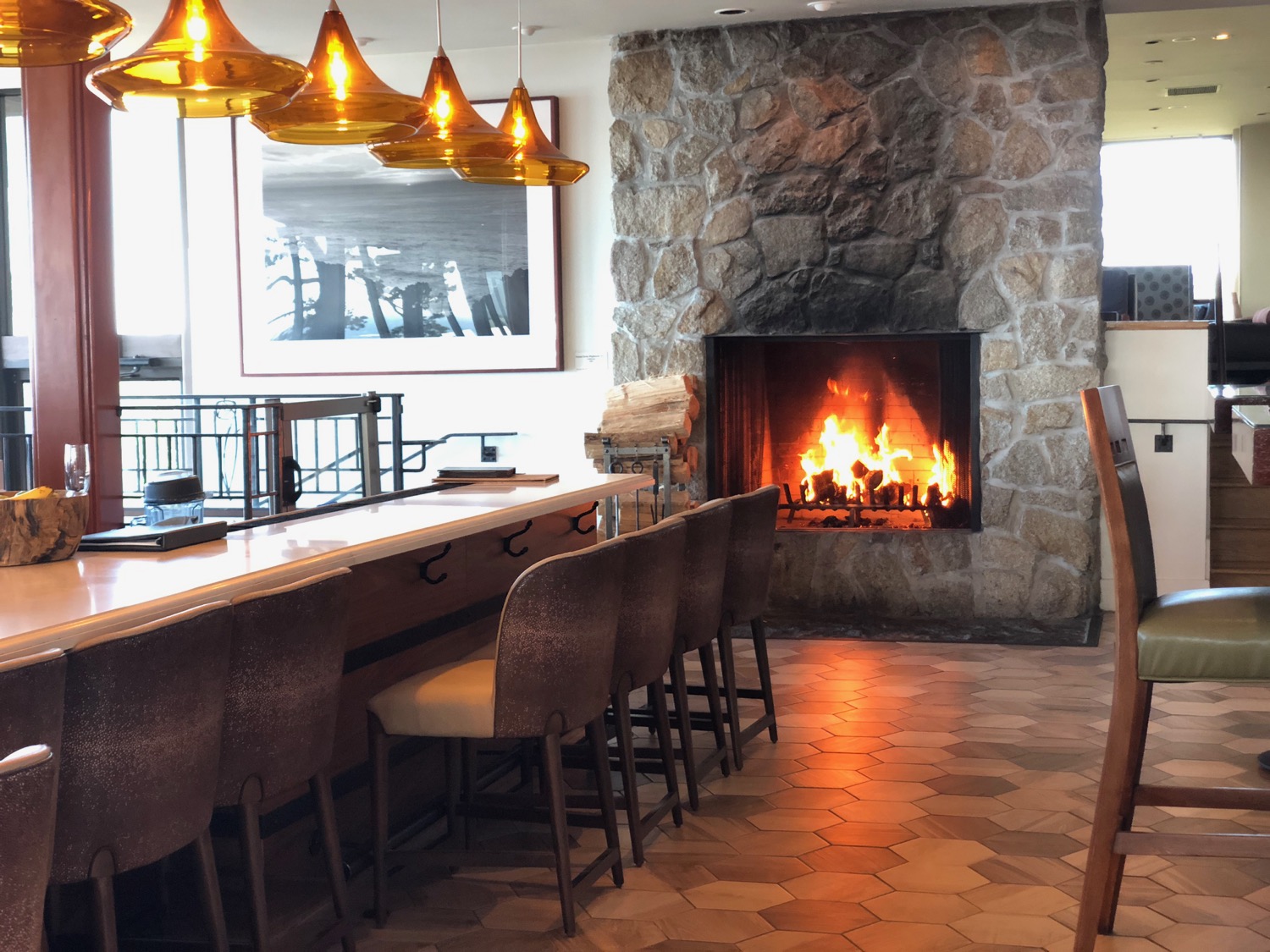 a bar with chairs and a fireplace
