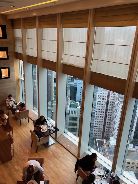 Tall windows in the lounge, stunning urban views, Victoria Harbour barely visible. 