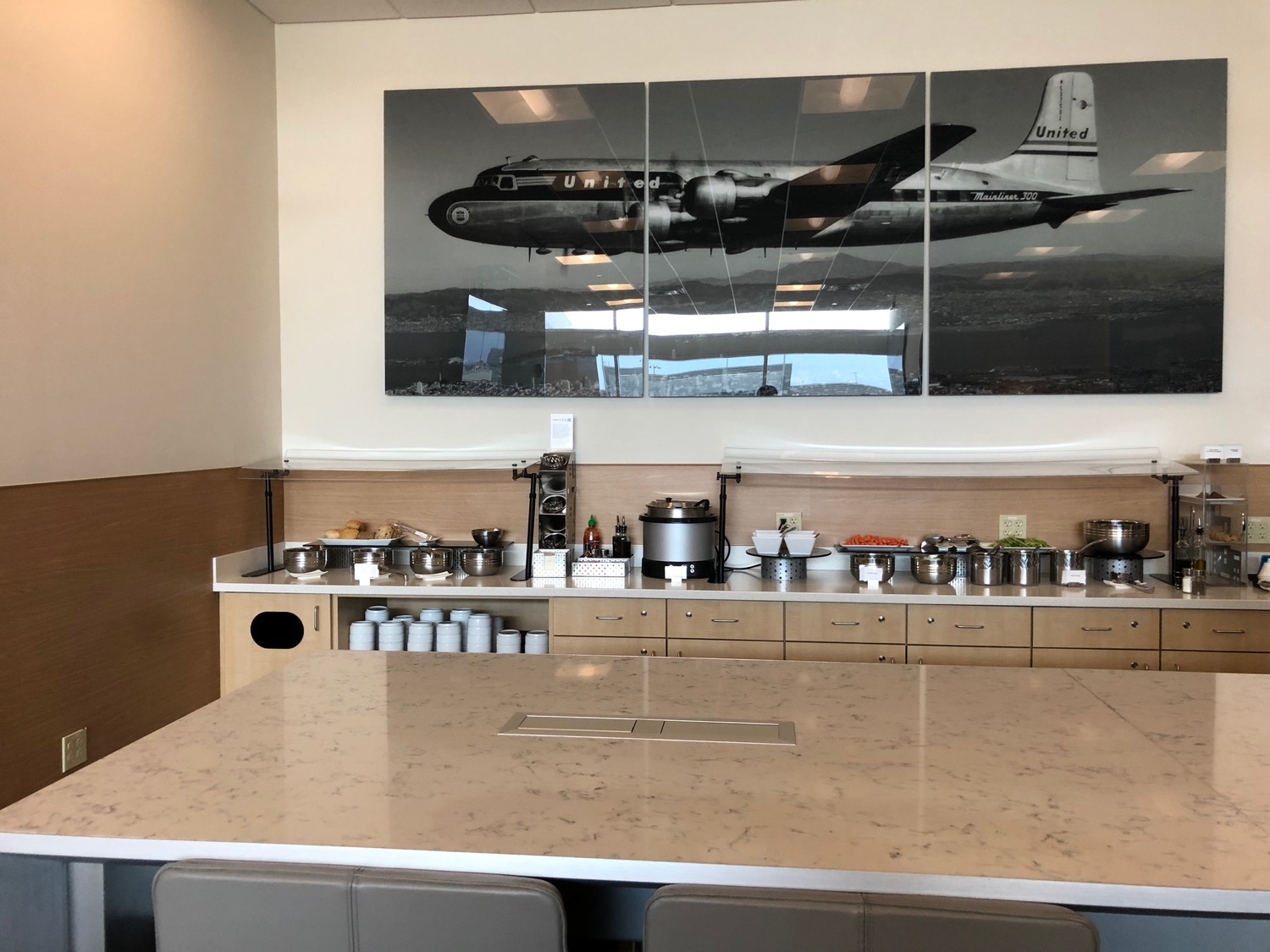a kitchen with a large table and a large picture of an airplane