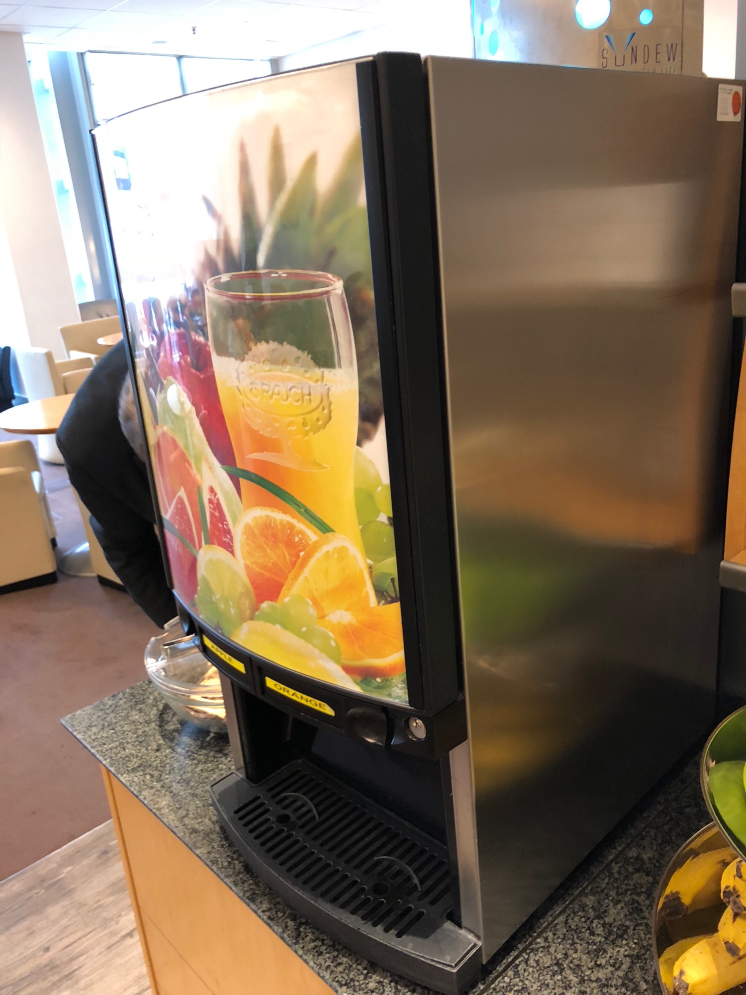 a beverage dispenser with a picture of a glass of orange juice
