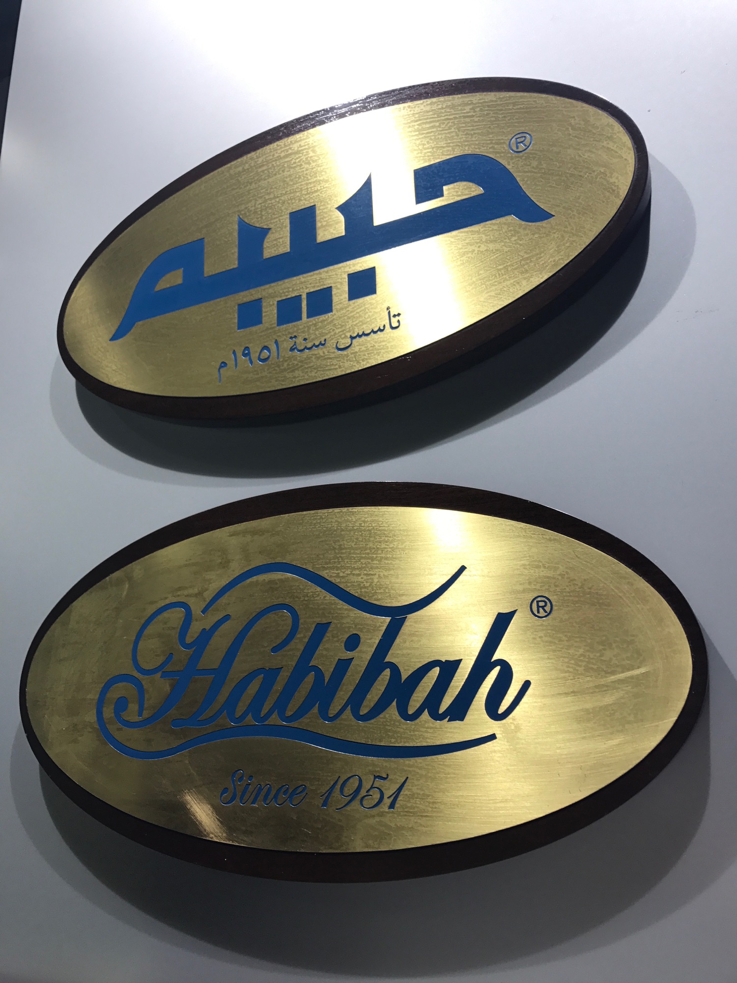 a gold oval sign with blue writing