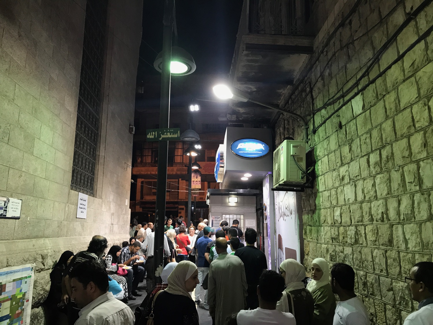a group of people walking down a narrow alley