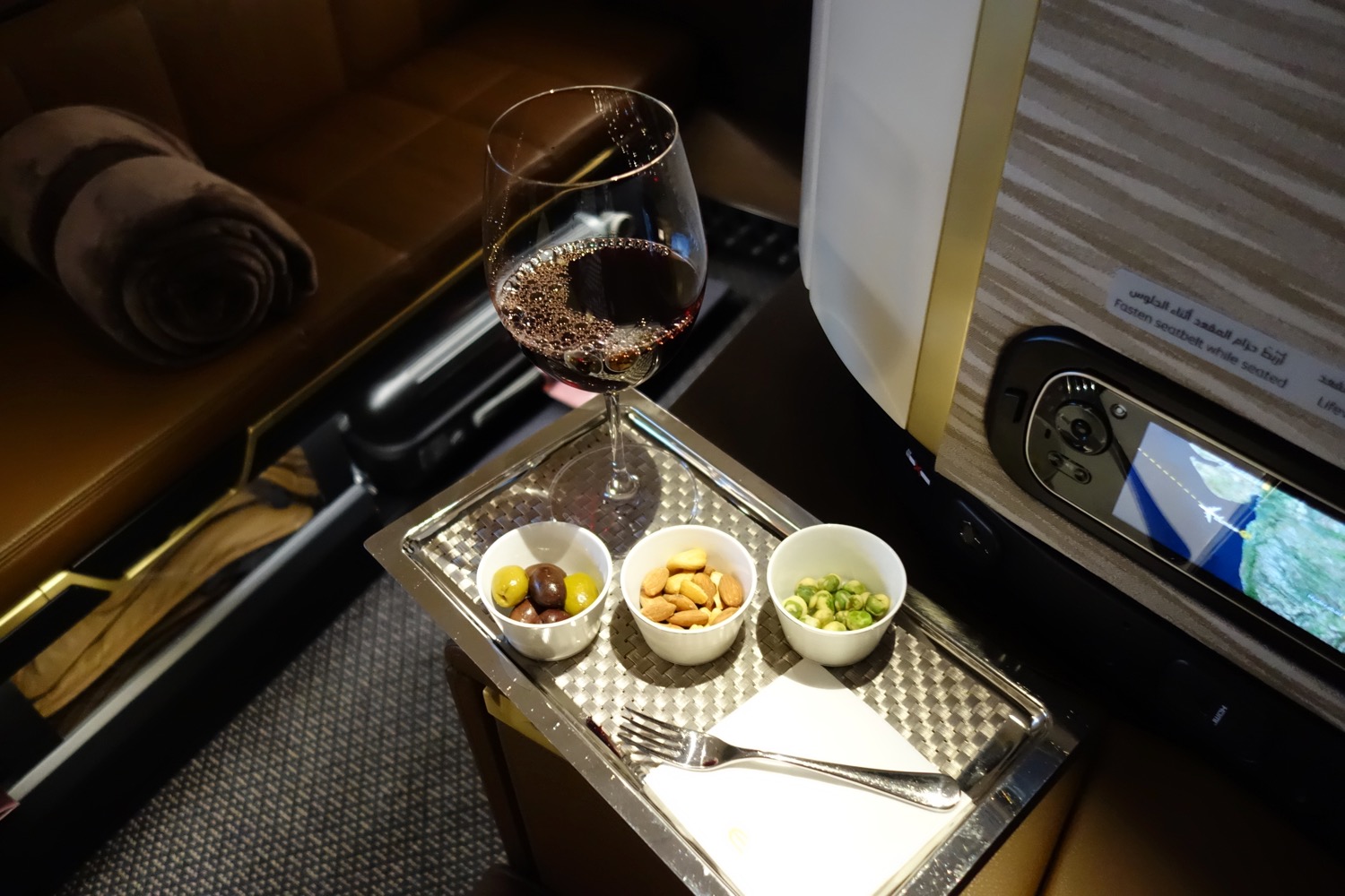 a tray with food and a glass of wine on it