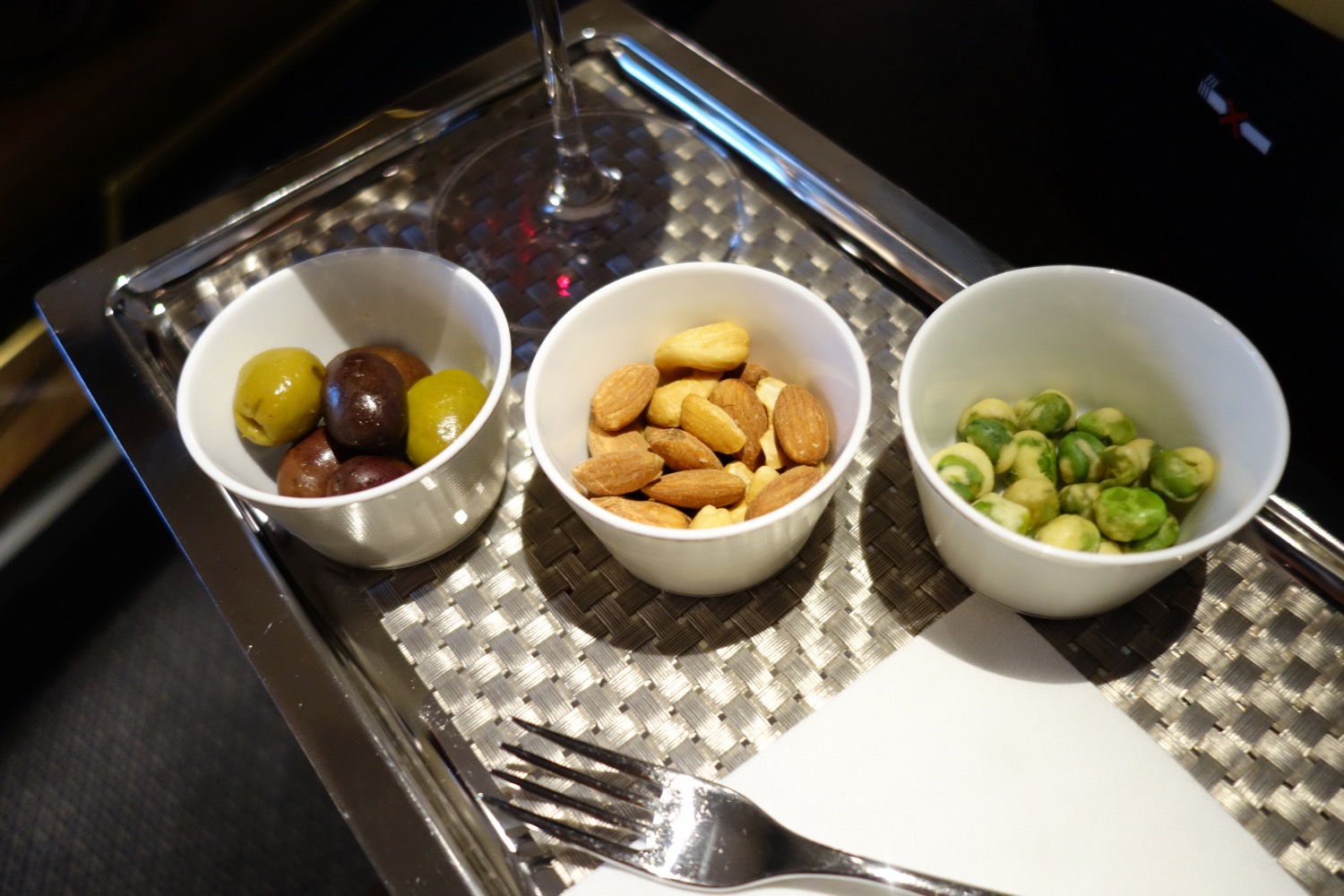 a group of bowls of nuts and olives on a tray