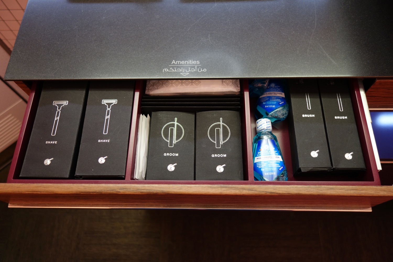 a drawer with black boxes and a bottle of water