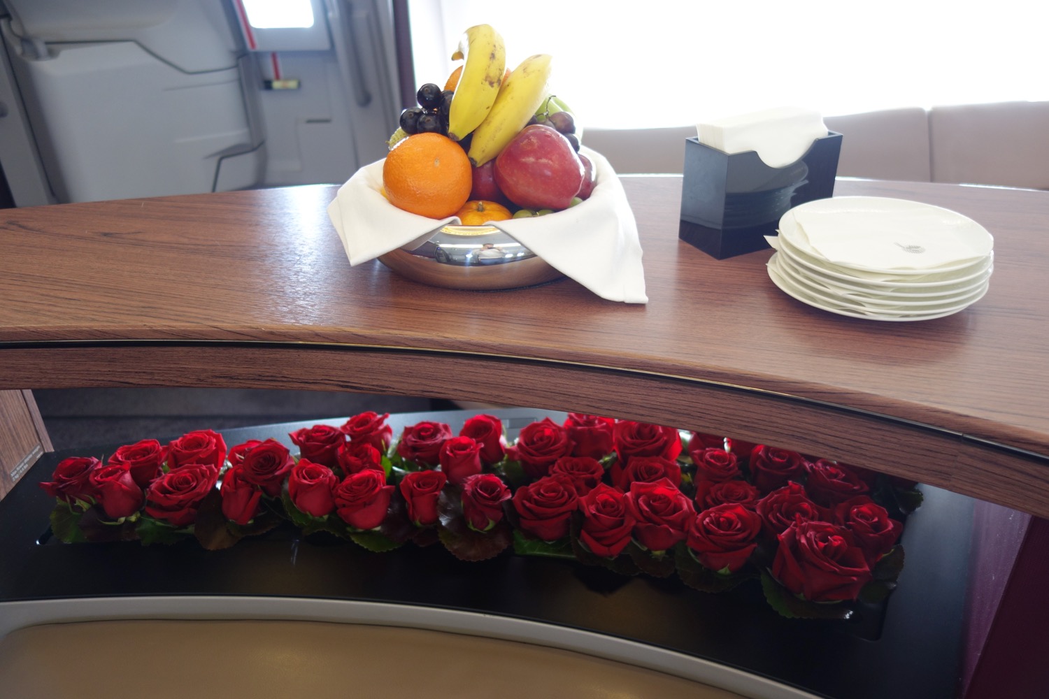 a bowl of fruit and roses on a table