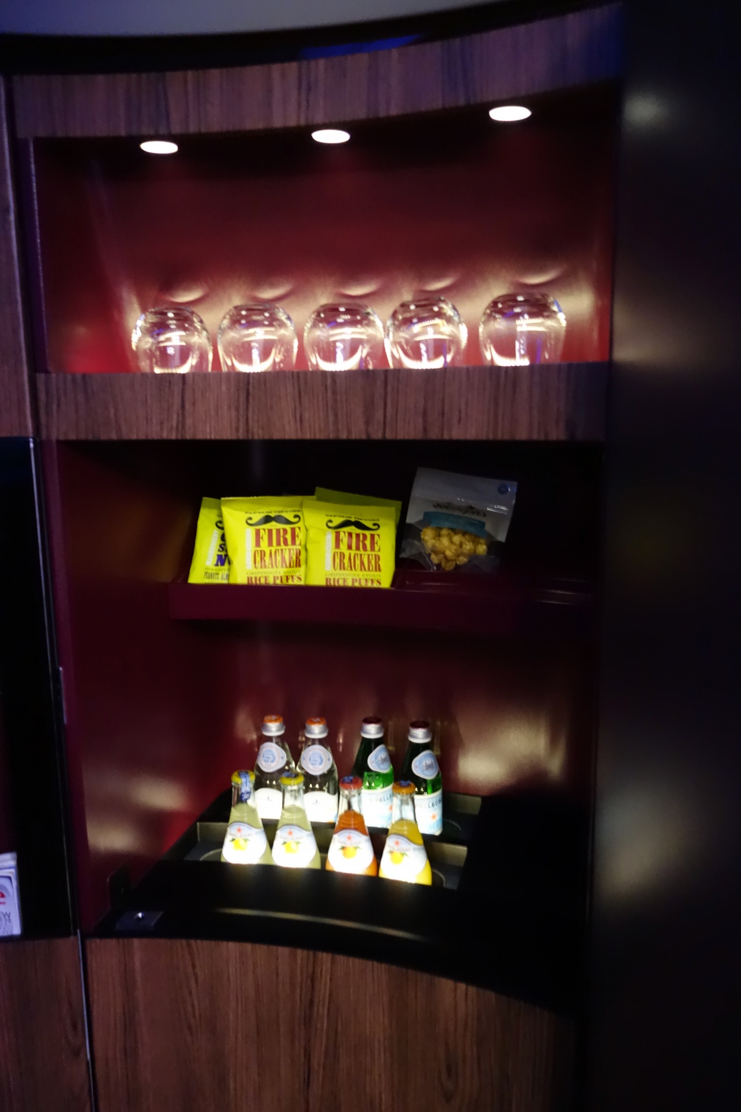 a shelf with glasses and snacks on it