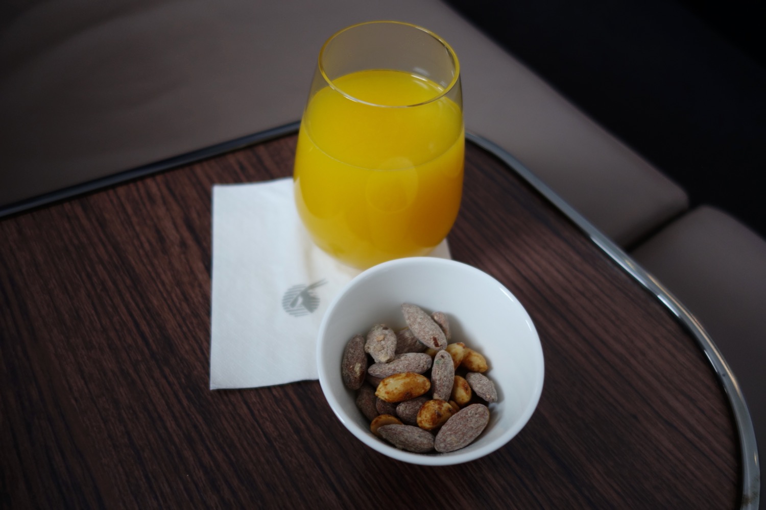 a bowl of nuts and a glass of orange juice