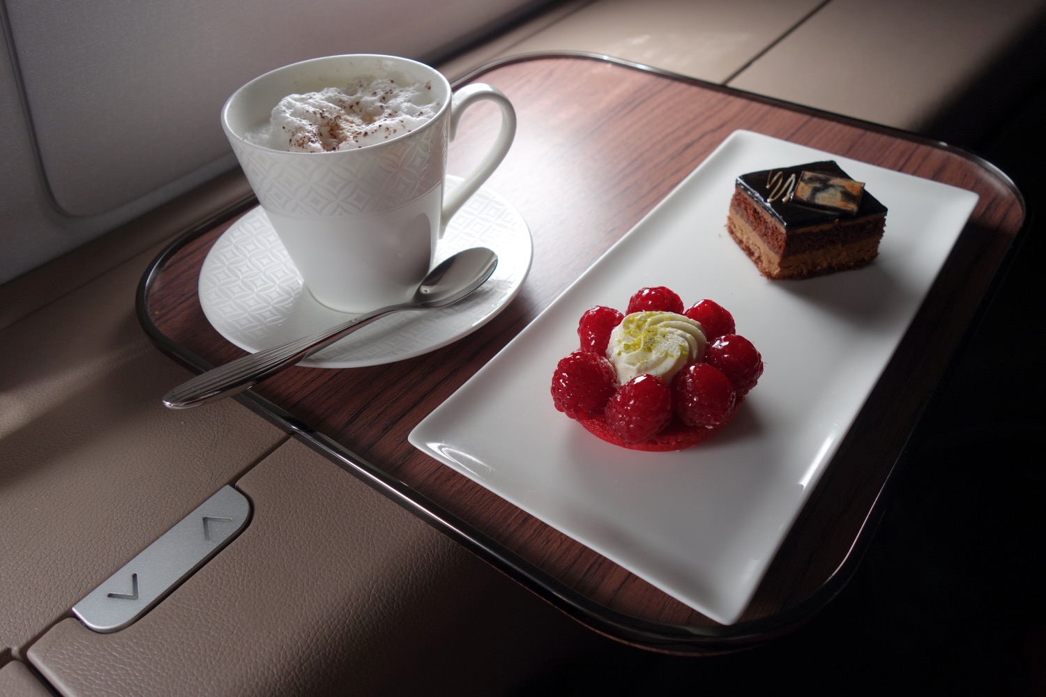 a cup of coffee and dessert on a tray