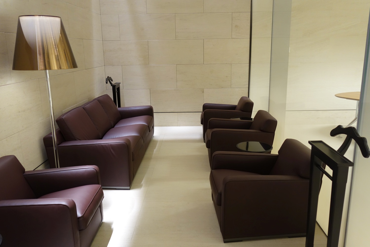 a room with brown leather couches and chairs