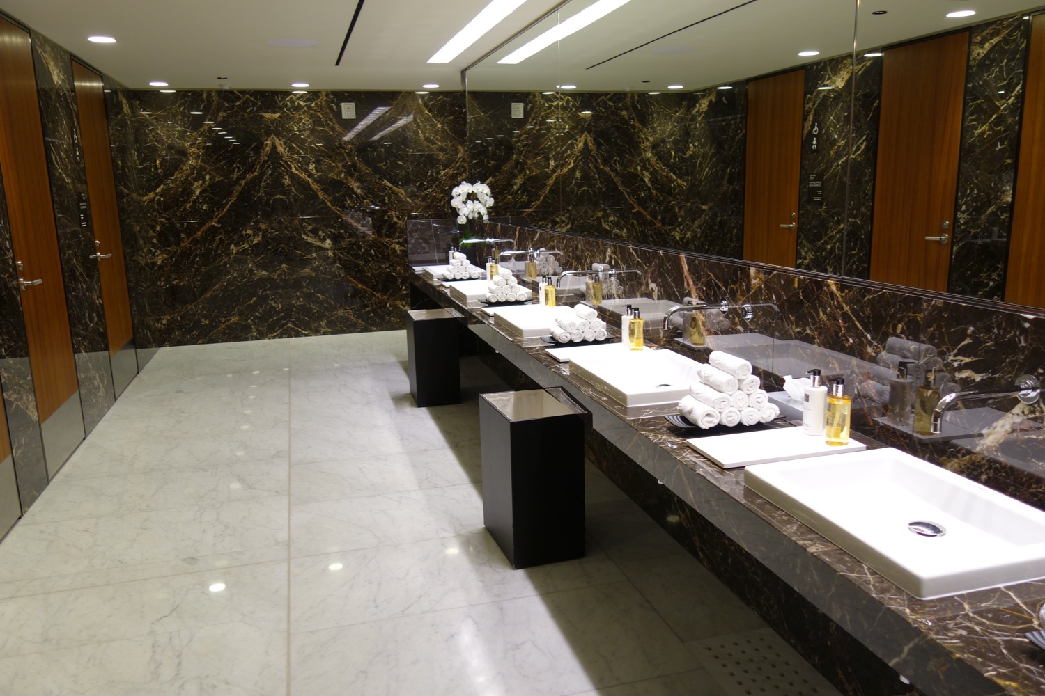 a bathroom with marble walls and sinks