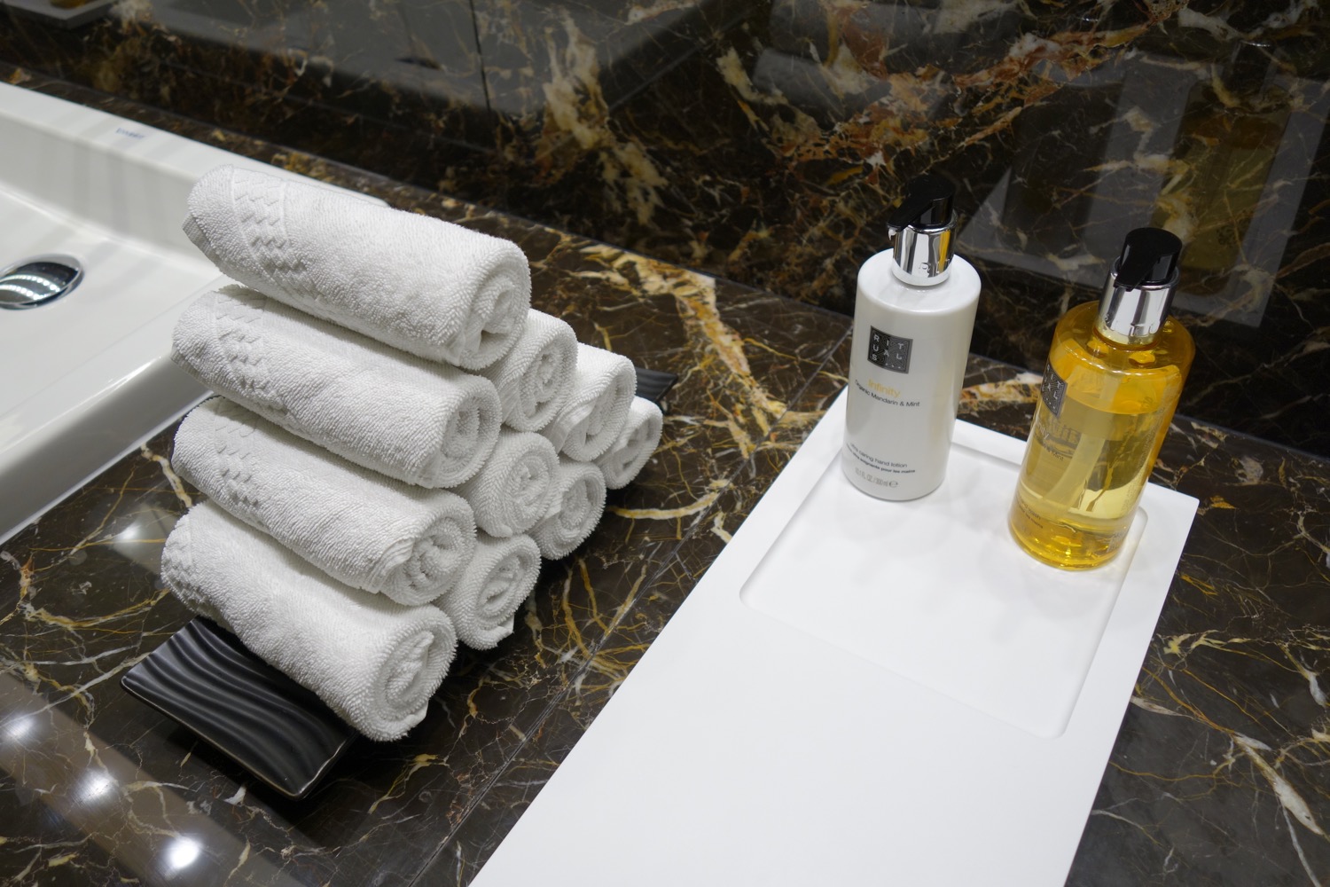 a stack of towels and bottles on a counter