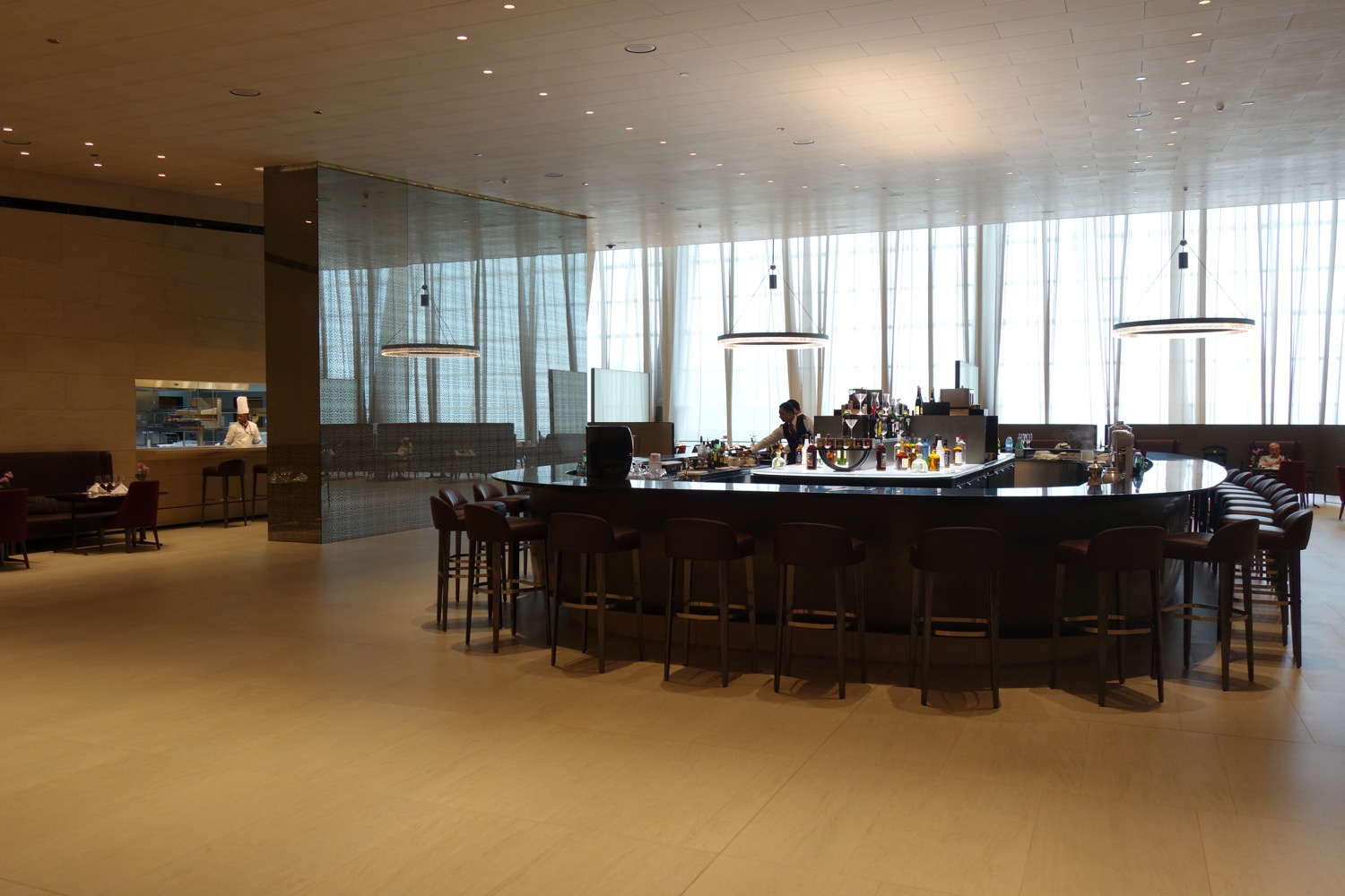 a bar with a counter and chairs in a large room