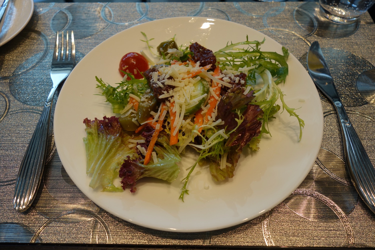 a plate of salad with a fork and knife