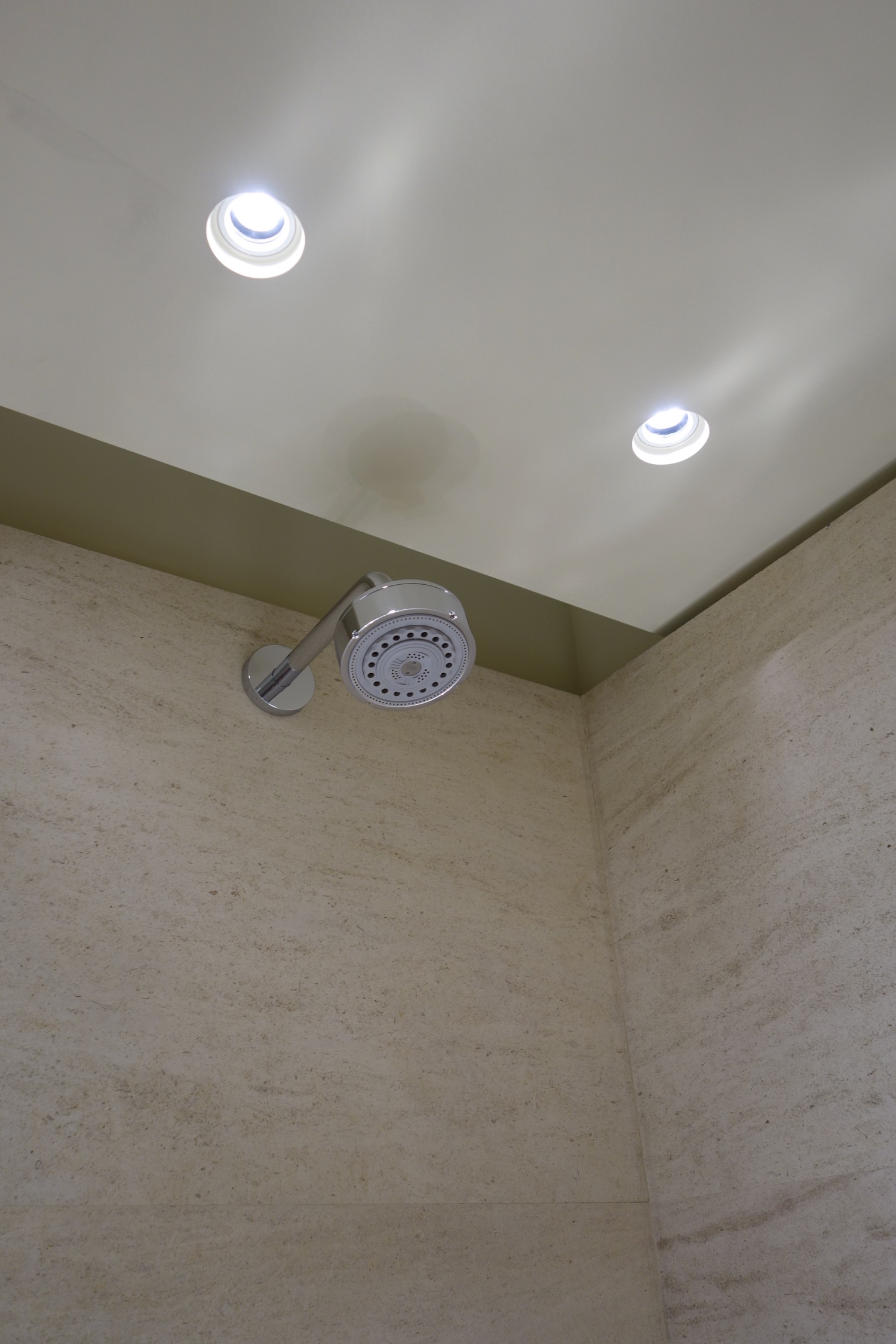 a shower head with lights on the ceiling