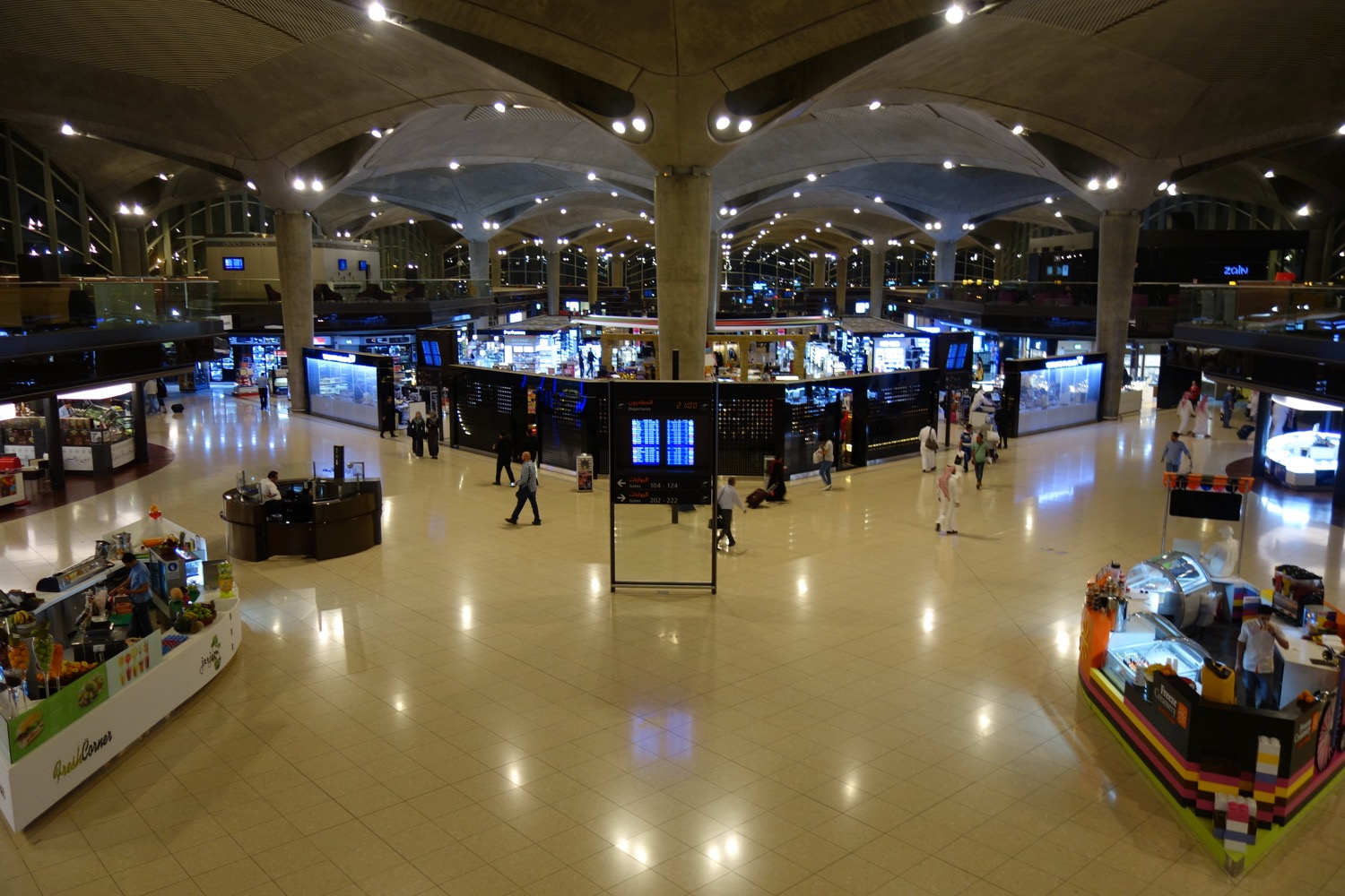 a large airport terminal with people walking around
