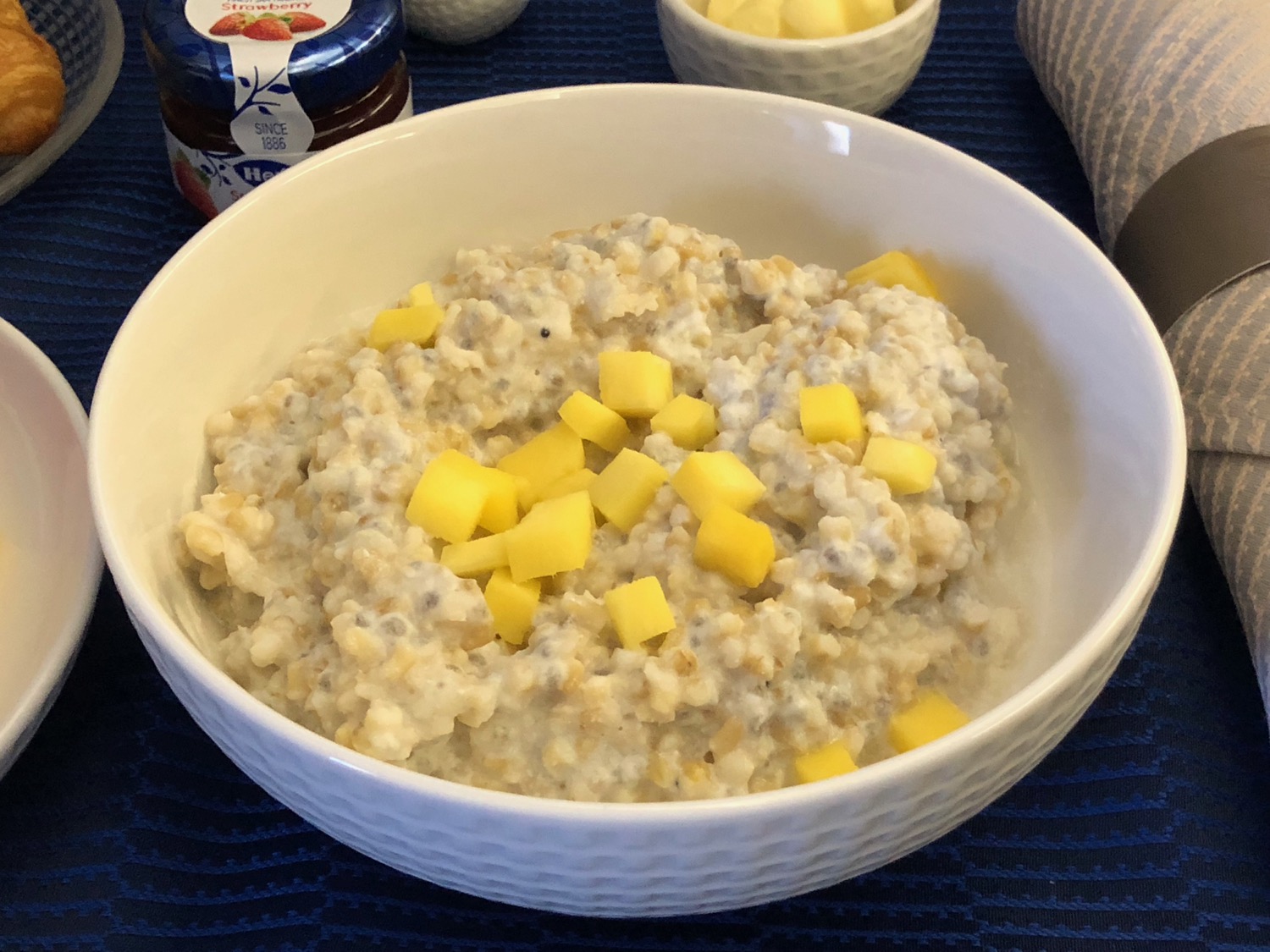 a bowl of oatmeal with mango cubes
