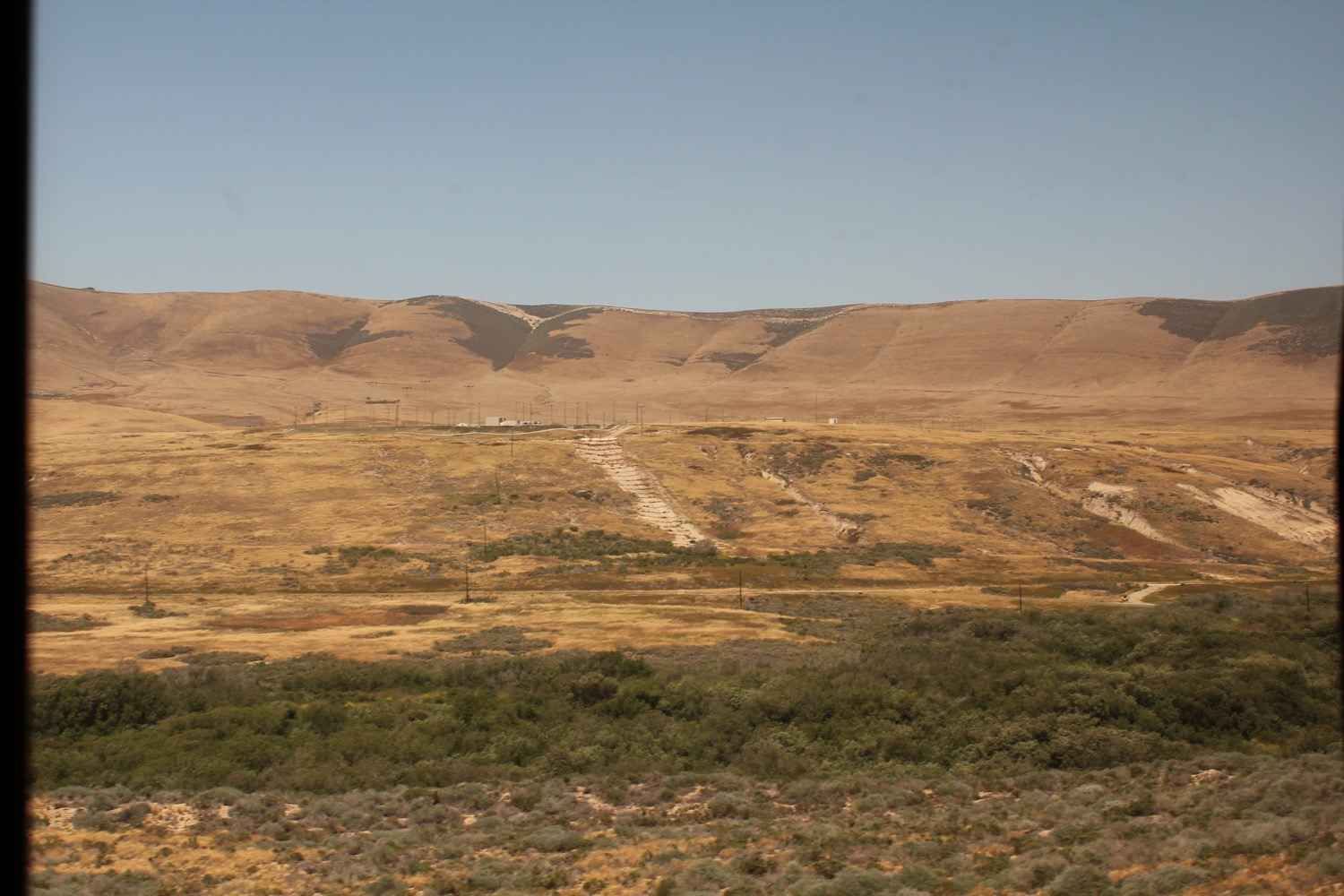 a landscape of a desert with hills and a blue sky