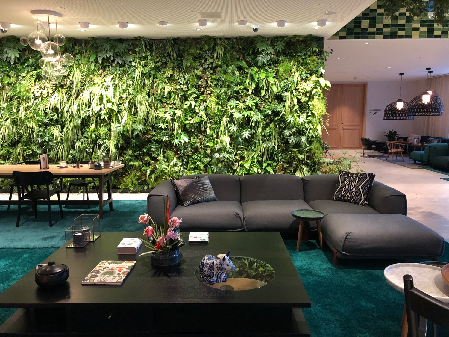 a living room with a green wall and plants
