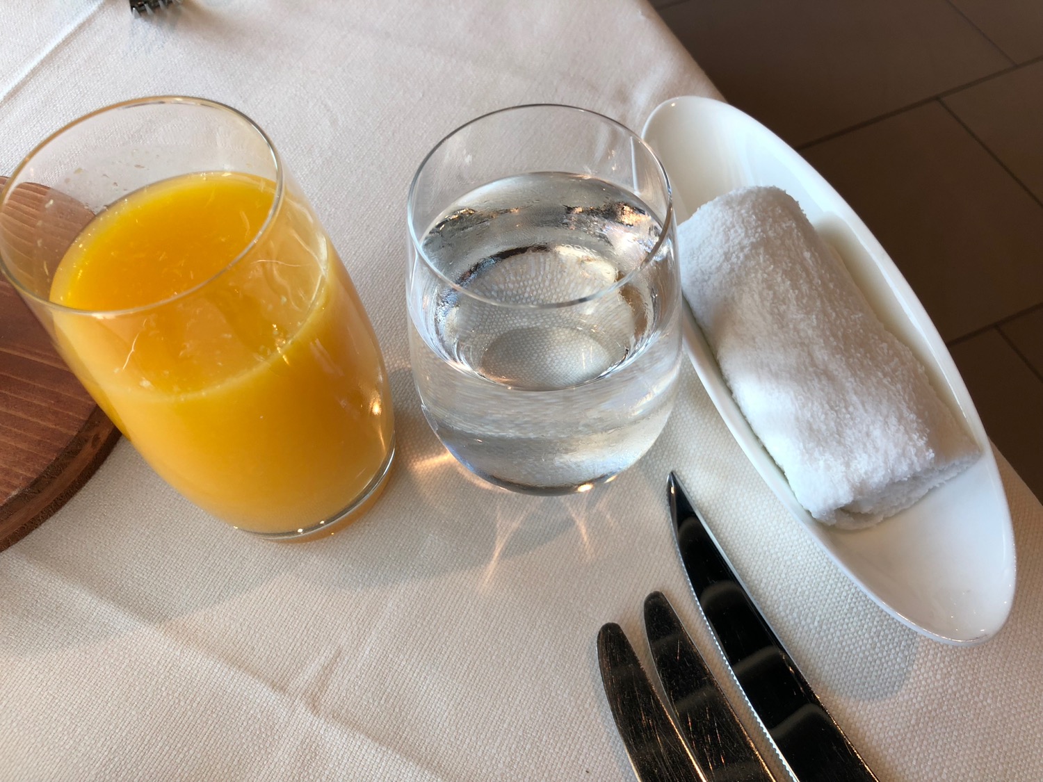 a plate of water and a glass of orange juice on a table