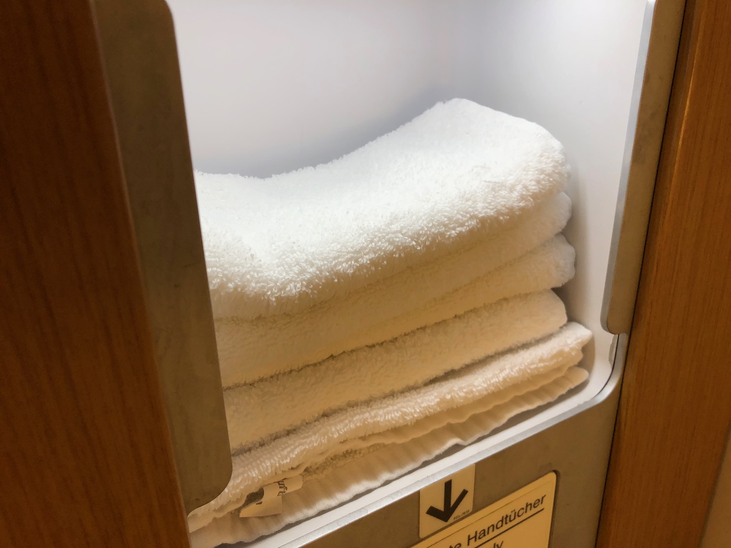a stack of white towels in a cabinet