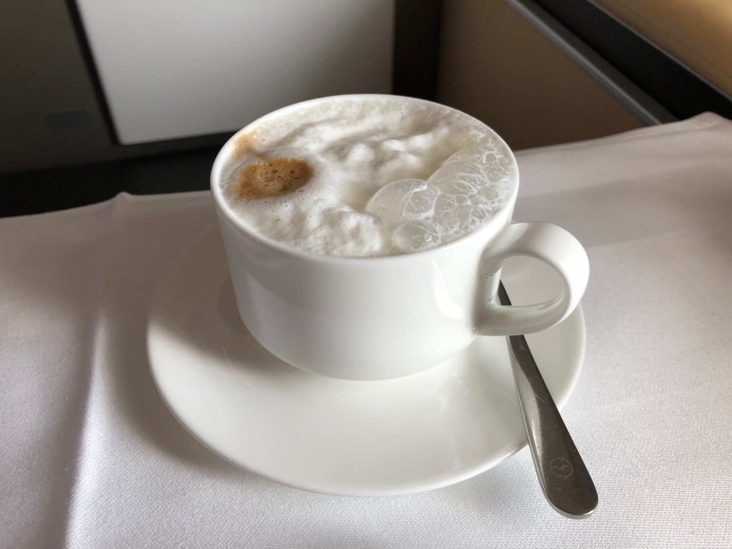 a cup of coffee with foam and a spoon