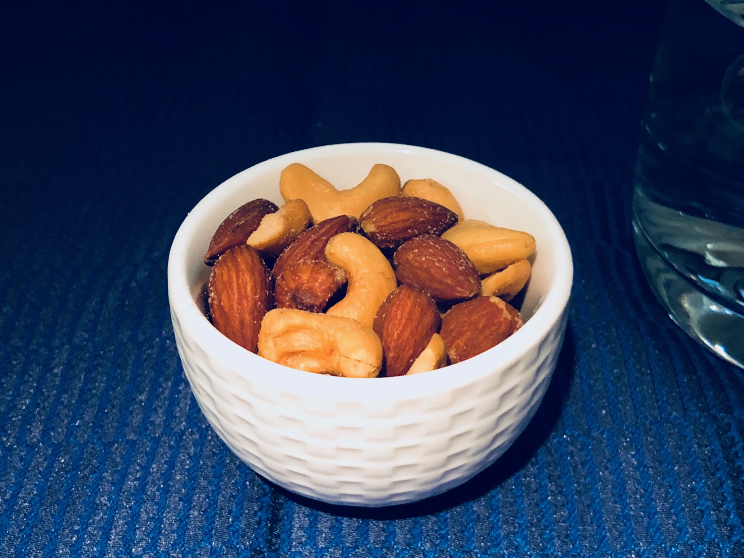 a bowl of nuts on a blue surface