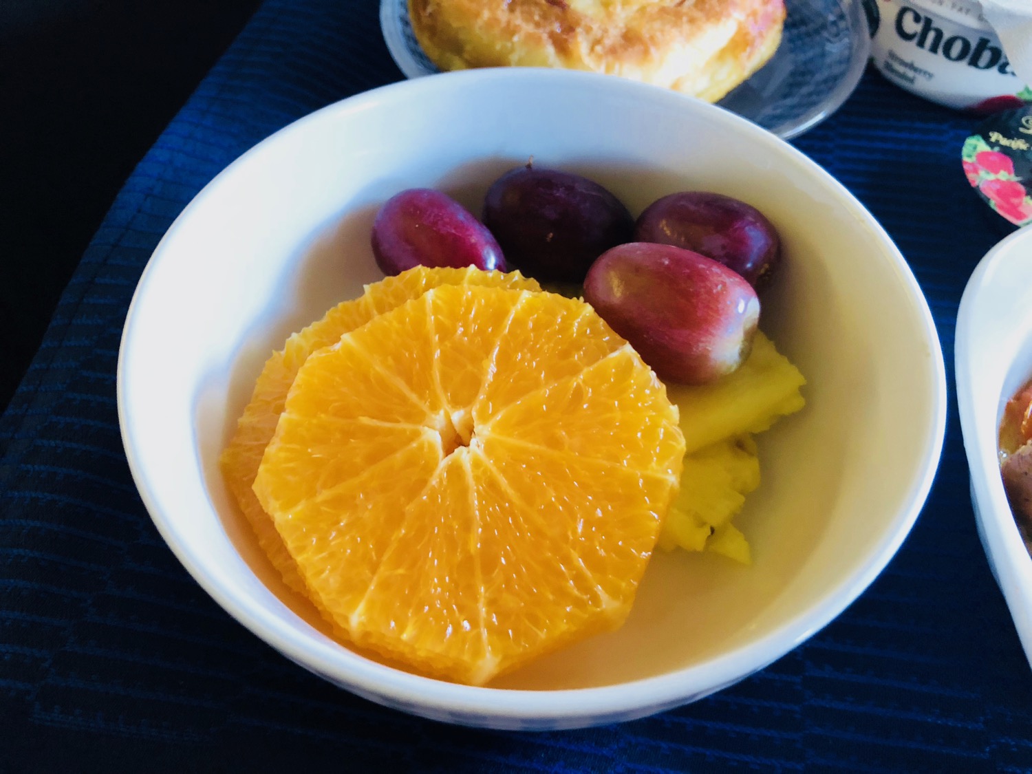 a bowl of fruit and a bagel