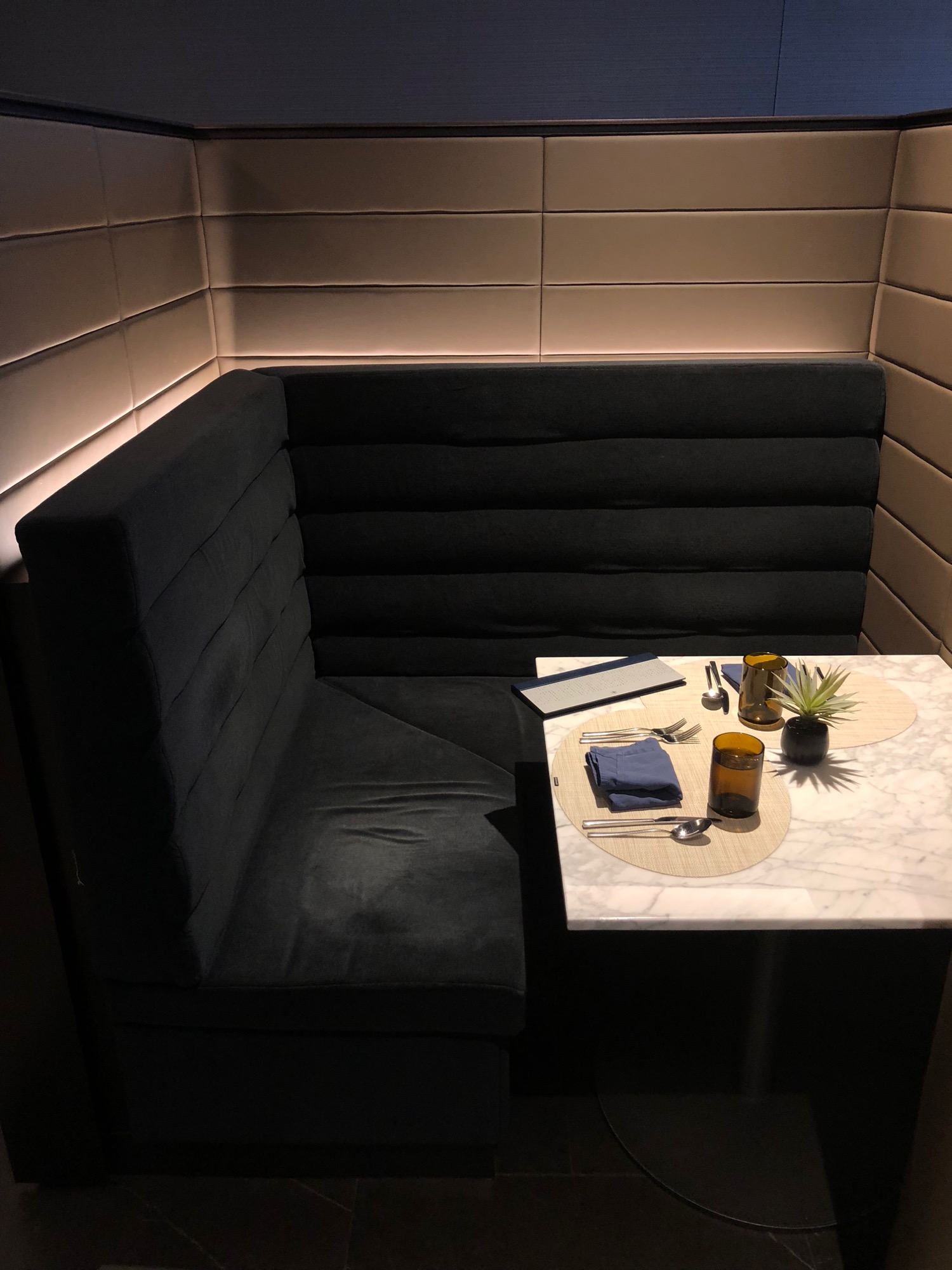 a corner booth with a table and a black chair